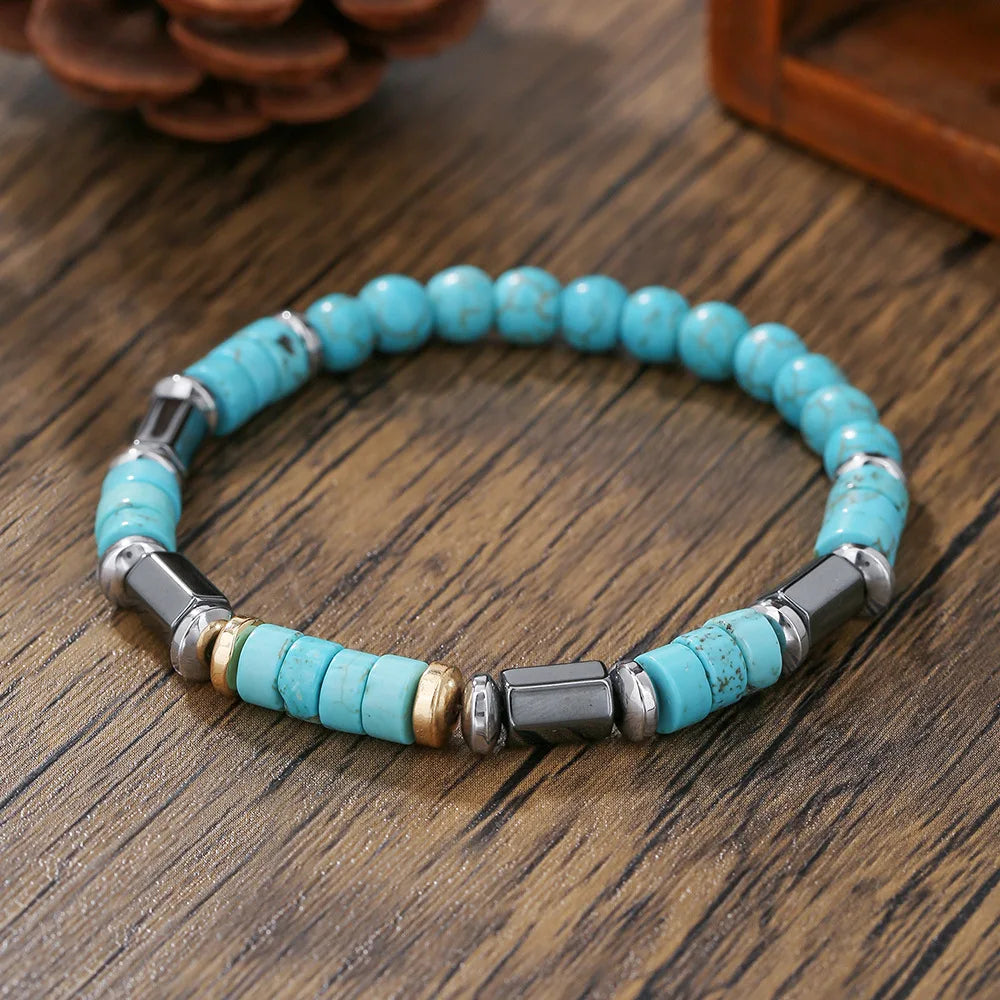 Turquoise beaded bracelet with metal accents on a wooden surface